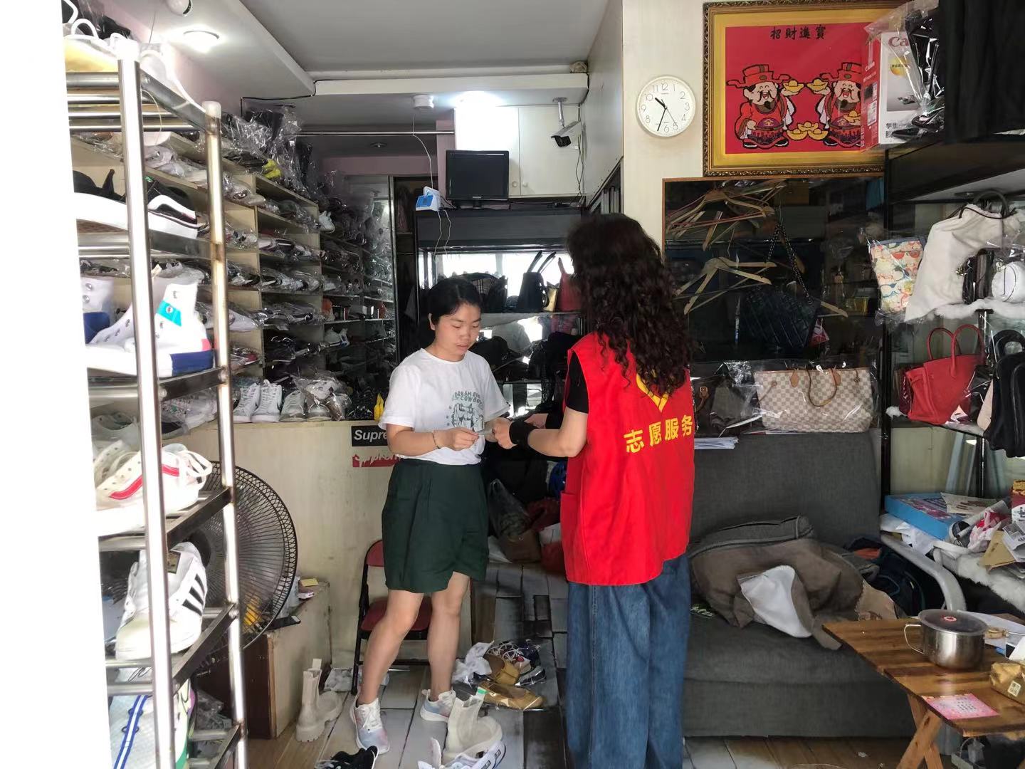 志愿者对辖区店铺进行垃圾分类宣传